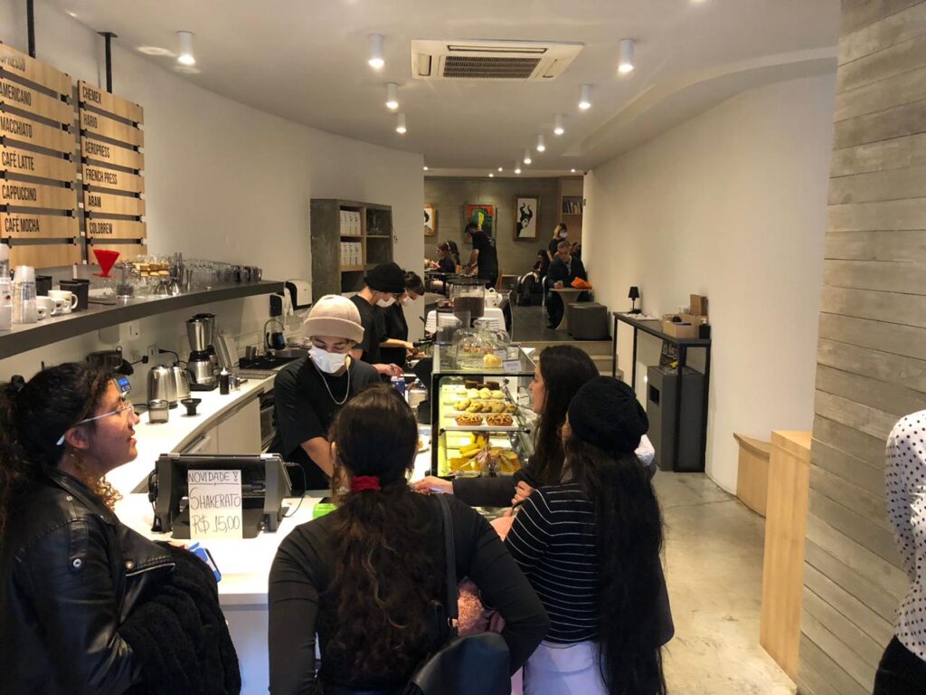 pessoas aguardando em um balcão de cafeteria