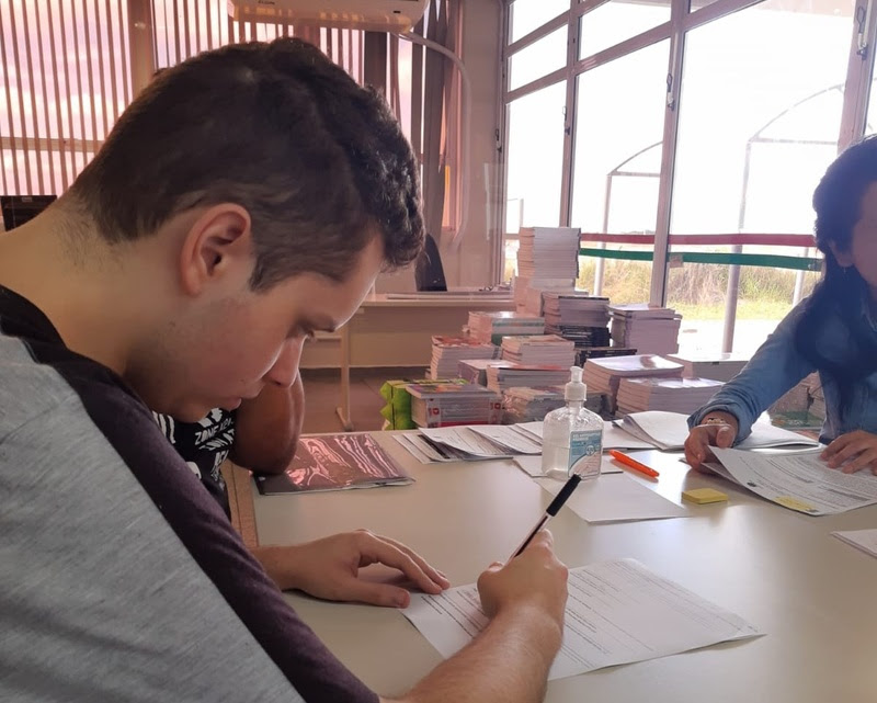 estudante assinando um papel