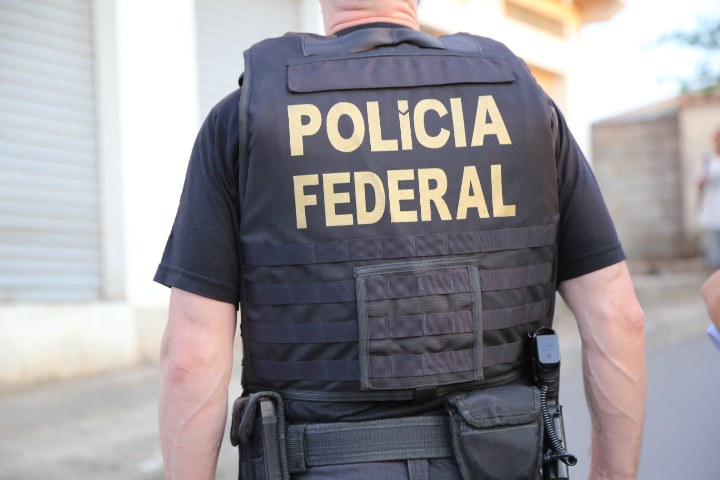 policial branco de costas com colete a prova de balas